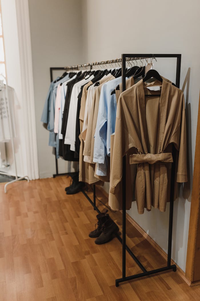 Stylish trench coats and garments elegantly displayed on a clothing rack in a boutique setting.
